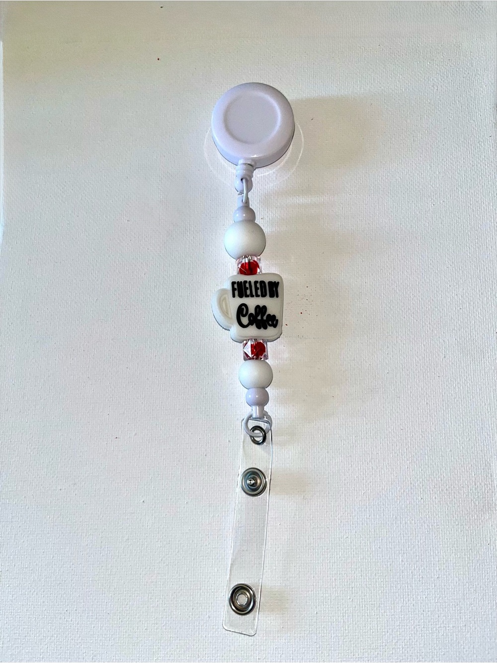 White Beaded Badge Reel with "Fueled by Coffee" Accent
